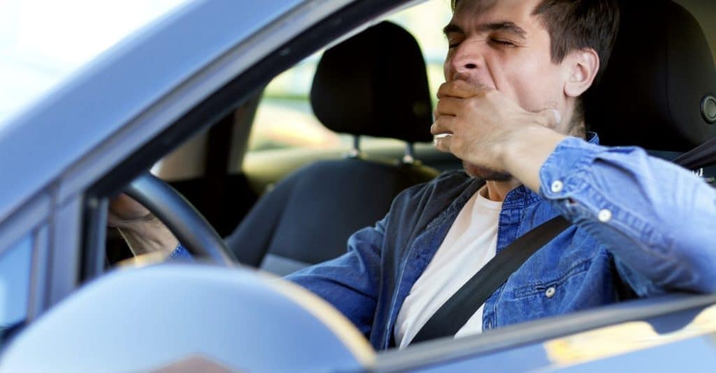A drowsy driver driving his car.