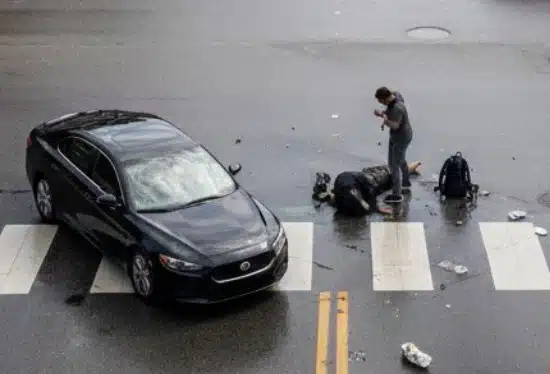 A daytime street scene showing a pedestrian accident at a crosswalk in a Texas city